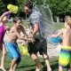 kids splash adult with water at camp